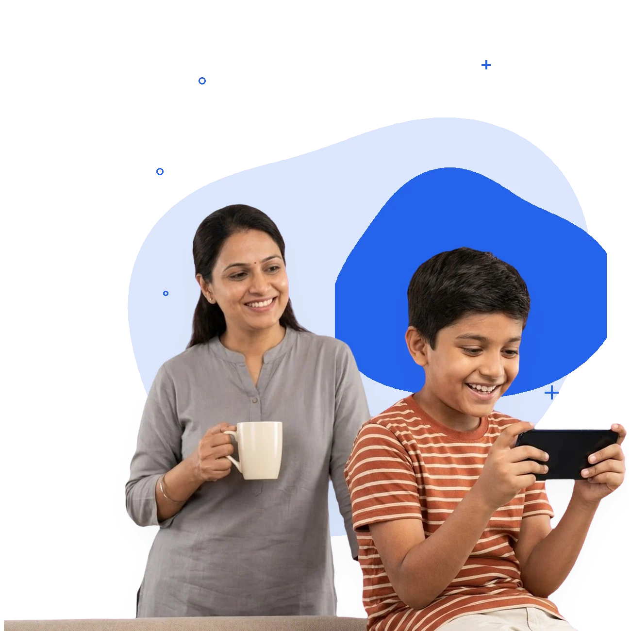 A boy grins at a game on his phone while his mother, holding a mug, watches him without interrupting.